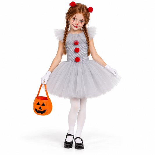 Fillette en déguisement de clown Halloween, robe tutu grise à pompons rouges, gants et collants blancs, avec un sac citrouille.