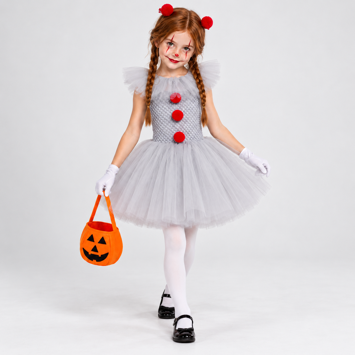 Déguisement de clown enfant porté en mouvement, avec robe tutu grise à pompons rouges, gants, collants blancs et sac citrouille.
